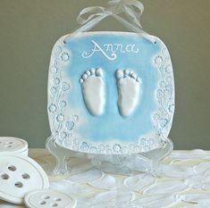 a blue and white baby's foot print on a glass block with buttons next to it