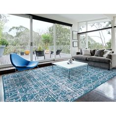 a living room filled with furniture next to a large glass window covered in lots of windows