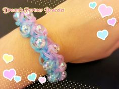 the bracelet is decorated with blue and pink beads on it's arm, while hearts are scattered all around