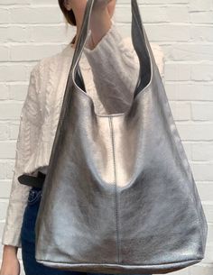 BACK IN STOCK! A simply stunning & stylish, metallic leather slouch bag with matching purse. ABOUT THE BAG.. 4 stunning colours available. Open top with magnetic dot closure. Additional zipped purse attached via a chain.  Silver metal hardware.   Handle drop: 38cm. Dimensions: H60cm x W37cm x D16cm  Handmade in Italy  All orders are dispatched within 1-3 working days from the UK via Royal Mail. Leather Slouch Bag, Personalized Family Print, Family Pet Portraits, Slouch Bag, Purse Outfit, Slouchy Bag, Slouch Bags, Silver Bags, Gold Bag