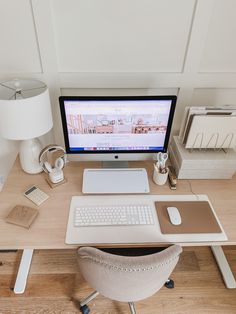 a desk with a computer, keyboard and mouse on it in front of a lamp