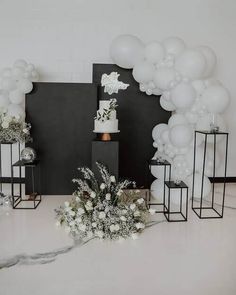 a table topped with lots of white balloons and flowers