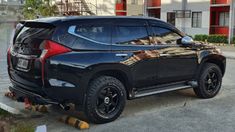 a black suv parked in front of a building