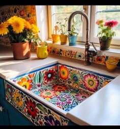 a kitchen sink with colorful flowers painted on the front and side, next to a window