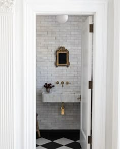 an open door leading to a bathroom with black and white checkerboard flooring