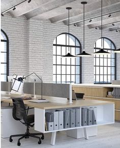 an office with two desks and several file folders in front of large windows