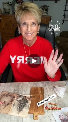 a woman sitting at a table with christmas cards