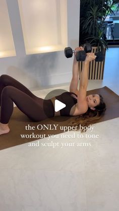 a woman is doing an exercise with dumbbells on her stomach and arms, in front of a white wall