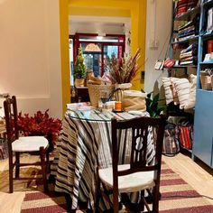 a dining room table covered with a black and white striped cloth next to a blue bookcase filled with books