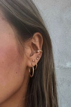 a woman wearing two gold hoop earrings with the word spotted in front of her ear