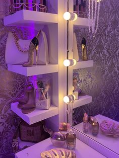 there is a lighted shelf in the room with shoes and purses on it next to a mirror