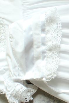 Designed to coordinate with our heirloom christening gowns, this vintage-inspired bonnet in 100% cotton is finished with crocheted lace and satin ribbon ties. Many of you requested a larger bonnet option, so we added a size 12 month bonnet, sold separately, to be worn with our Savannah dress, Virginia dress, or Margaret dress. Bonnet is available in white or ivory. Fitted White Bonnet With Lace Trim, Elegant Lace Bonnet With Lace Trim, White Fitted Bonnet For Baptism, Fitted White Bonnet For Baptism, Wedding Bonnet With Lace Trim, Fitted Cotton Bonnet With Lace Trim, Fitted Cotton Baptism Dress With Lace Trim, Fitted Cream Bonnet With Lace Trim, White Cotton Bonnet For Baptism