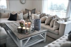 a living room filled with lots of furniture and candles on top of a coffee table