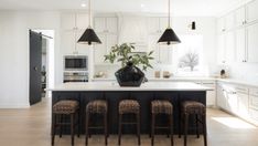 a kitchen island with four stools in front of it