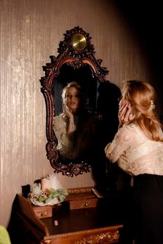 a woman looking at herself in the mirror