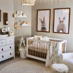 a baby's room with two pictures on the wall and a white crib