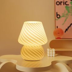 a white lamp sitting on top of a table in a living room next to a chair