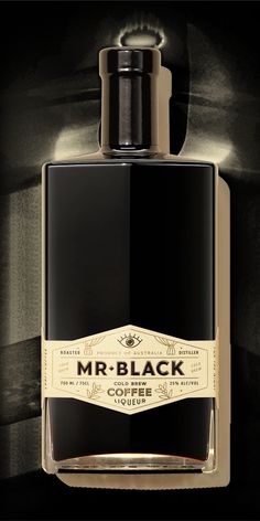 a bottle of mr black cologne sitting on top of a table next to a wall