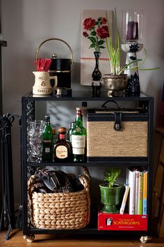 a shelf filled with bottles and glasses next to a basket on top of a table