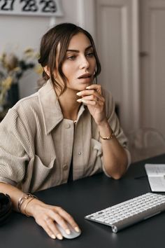 a woman sitting at a desk with a keyboard and mouse in front of her face