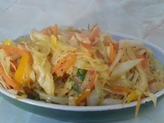 a bowl filled with coleslaw and carrots on top of a white table