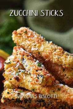 zucchini sticks are stacked on top of each other with sauce in the background