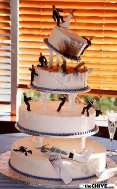 a three tiered wedding cake with figurines on top