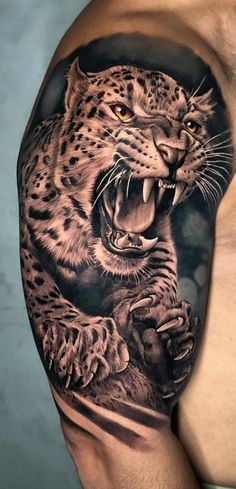 a man's arm with a black and grey tattoo of a leopard on it