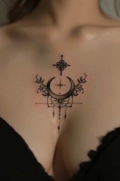 a woman's chest with a cross and crescent tattoo on the left side of her breast