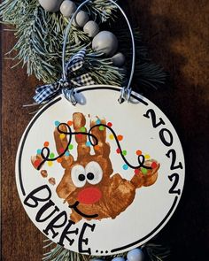 a handprinted ornament hanging from a christmas tree