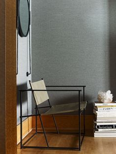 a chair and some books on a table in front of a wall with color swatches