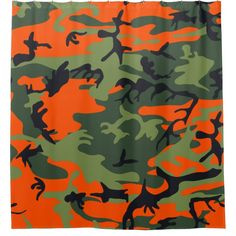 an orange and green camouflage shower curtain with black ink on the bottom, in front of a white background