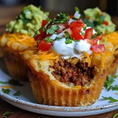 two taco cups on a plate with sour cream and toppings in the middle