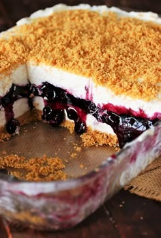 a pie with blueberries and crumbs in it sitting on a wooden table