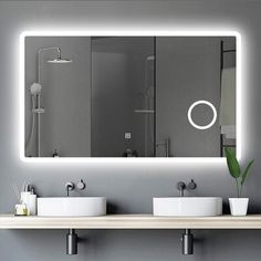 a bathroom with two sinks and a large mirror over it's wall mounted faucet