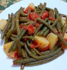 a white plate topped with green beans and potatoes