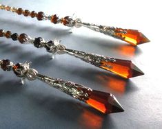 three pairs of orange crystal and silver necklaces