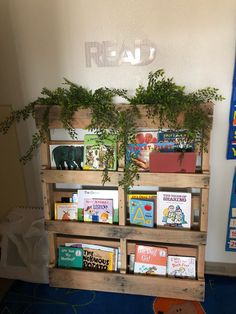 there is a wooden book shelf with books on it and plants growing out of the top