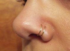 a close up of a person with a nose ring on their nose and one side of the nose