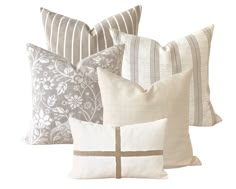 four pillows with different designs on them, one is white and the other is grey