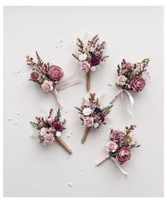 four bouquets of flowers are arranged on a white surface