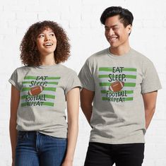 two people wearing t - shirts that read eat sleep football repeat and smile at the camera