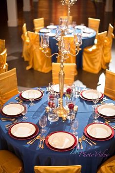 the table is set with plates, silverware and candlesticks for an elegant dinner