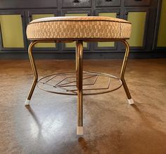 a chair with a foot rest sitting on top of a hard wood floor next to cabinets