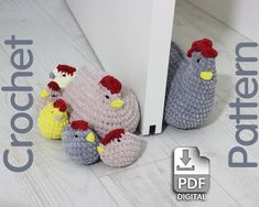 two crocheted chickens sitting next to each other in front of a white door