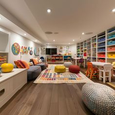 a living room filled with lots of furniture and colorful pillows on top of it's floor