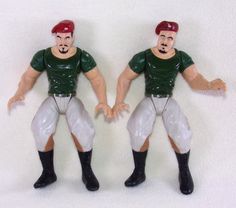 two toy figurines wearing green and white football uniforms