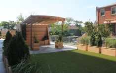 an outdoor area with wooden planters, grass and fenced in areas around it