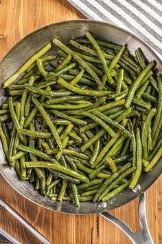 cooked green beans in a pan on a wooden table