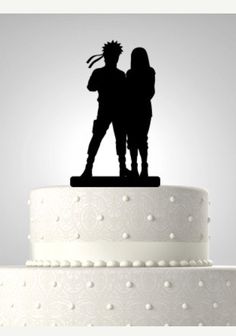 the silhouette of two people are standing on top of a cake